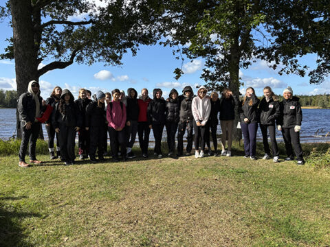 Elever från Sunnerbogymnasiet på stranden vid sjön Bolmen.