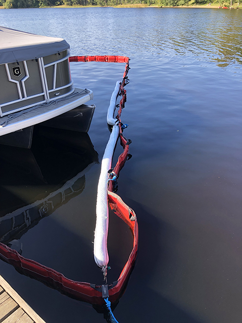 Flytläns (röda) och absorbtionsläns (vita) i vatten bakom en båt.